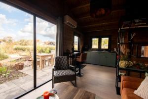 een woonkamer met een groot raam en een tafel bij NIEUW Bed & Breakfast Puur Poortugaal in Poortugaal