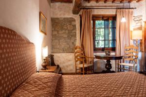 a bedroom with a bed and a table and a window at Fattoria degli Usignoli in San Donato in Fronzano +164 photos