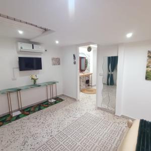 la casetta di Francesco في Sant'Egidio del Monte Albino: غرفة معيشة بجدران بيضاء وتلفزيون على الحائط