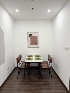 a table and chairs in a room with a painting at 1998Homestay Căn hộ 1n1wc city view tiện nghi in An Khê