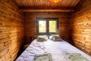 een bed in een houten kamer met een raam bij NIEUW Bed & Breakfast Puur Poortugaal in Poortugaal