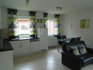 a kitchen with a refrigerator and a table and chairs at Ferienwohnung Hilbers in Horumersiel