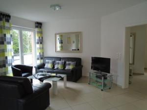 a living room with a couch and a tv at Ferienwohnung Hilbers in Horumersiel