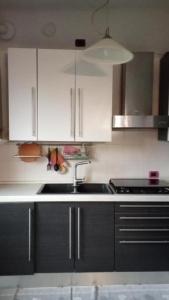 a kitchen with white cabinets and a sink at Novara dormi e vai in Novara