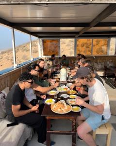 a group of people sitting around a table eating food at Ami D'or Hostel in Taghazout