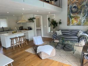 een keuken en een woonkamer met een bank en een tafel bij Magnolia Cottage in Kaapstad
