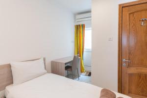 ein Schlafzimmer mit einem Bett mit Holztür und einem Schreibtisch in der Unterkunft Cozy Apartment in Malta in St Paul's Bay