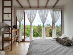 a bedroom with a bed and a large window at Nai Suan Phan Resort - ในสวนฝัน รีสอร์ท in Ban Thung Samoe