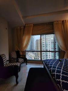 een slaapkamer met een bed en een groot raam bij Le luxe in Karachi