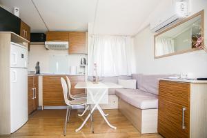 a small kitchen and living room with a table and a couch at Auto-kamp Dvije suze 2 in Brištane