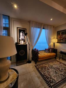 een woonkamer met een bank en een groot raam bij Le luxe in Karachi