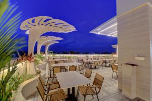 a restaurant with tables and chairs at night at Hotel Warma Palace in Yeola