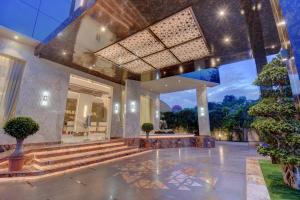 a lobby of a building with stairs and plants at Hotel Warma Palace in Yeola