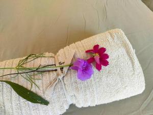 a red and purple flower on a white napkin at Nai Suan Phan Resort - ในสวนฝัน รีสอร์ท in Ban Thung Samoe