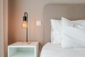 une lampe sur une table de nuit à côté d'un lit dans l'établissement HolidaysPT - Sunset At Lux Terrace - 2 Bedroom Apt, à Faro