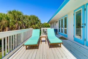 a porch with blue chairs on a house at Walk to Wabasso Beach Home with Hot Tub and Bikes in Sebastian