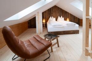1 dormitorio con 1 cama y silla de cuero en Bramsauerhof, en Faistenau 62 fotos más