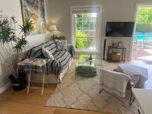 een woonkamer met een bank en een tafel bij Magnolia Cottage in Kaapstad