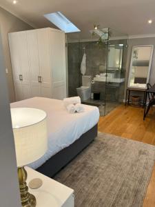 een badkamer met een bed, een bad en een wastafel bij Magnolia Cottage in Kaapstad +35 foto's