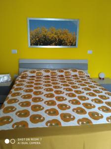 a large bed in a room with a yellow wall at B&B MASSERIA U Saliére in Sarconi