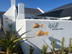 a wall with a sign that reads wild dinosaur clinic at Wild Riverside Cottage in Velddrif