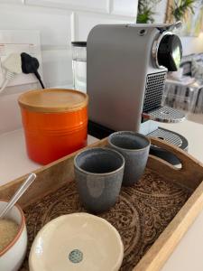 a tray with three cups on top of a kitchen counter at Magnolia Cottage in Cape Town