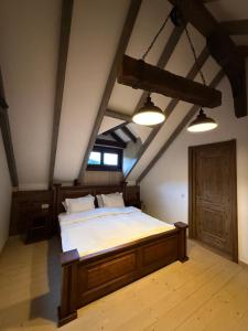een slaapkamer met een groot bed op een zolder bij Căsuțele Craiului in Zărneşti