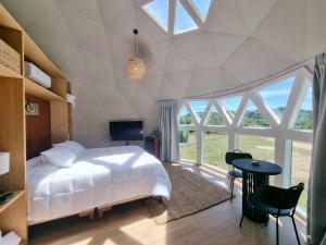 a bedroom with a white bed and a large window at Sierra Pacífica in Minas