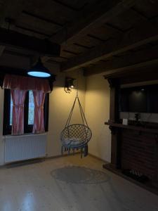 een kamer met een schommel aan een muur bij Căsuțele Craiului in Zărneşti