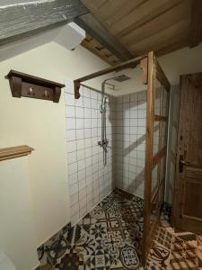 een badkamer met een douche en een tegelvloer bij Căsuțele Craiului in Zărneşti +17 foto's