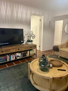a living room with a television and a coffee table at Wild Riverside Cottage in Velddrif
