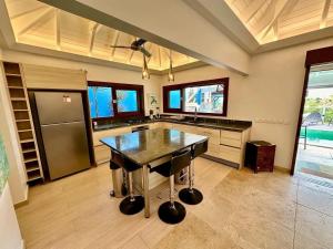 cocina grande con mesa y nevera en Modern Villa with Pool in Marigot - 100 m², en Marigot
