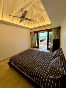 Un dormitorio con una cama con ventilador de techo. en Modern Villa with Pool in Marigot - 100 m², en Marigot 13 fotos más