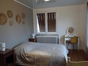 a bedroom with a white bed and a window at Les Petits Cailloux in Saint-Martin-lʼAstier