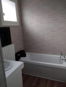 a bathroom with a bath tub and a sink at Les Petits Cailloux in Saint-Martin-lʼAstier