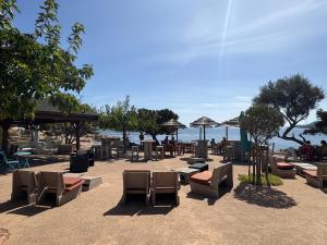 a group of chairs and tables on a beach at Village Naturiste La Chiappa in Porto-Vecchio