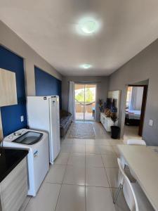 a kitchen with a white refrigerator and a table at O Rei Do Cumbuco - Cumbuco Residence in Caucaia