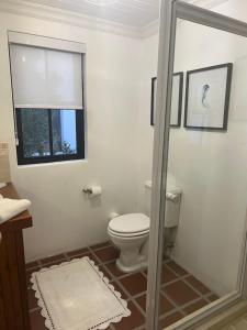 a bathroom with a toilet and a window at Wild Riverside Cottage in Velddrif +12 photos