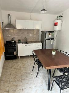 Una cocina con una mesa de madera y una mesa y sillas. en Casa de verano Marcos Lopez, en Villa Cura Brochero