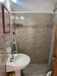 Un baño con lavabo y ducha en Casa de verano Marcos Lopez, en Villa Cura Brochero