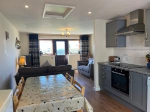 a kitchen and a living room with a table and a couch at Roan Cottage in Royal Wootton Bassett