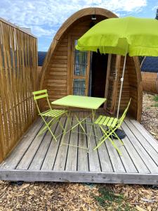 a table and two chairs and an umbrella on a deck at Pod Anis in Saint-André