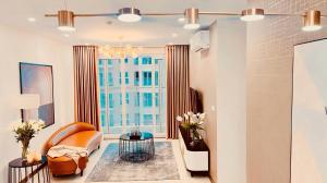 a living room with a couch and a window at New Life Bai Chay Condotel - Từ 1 đến 5 Phòng Ngủ in Ha Long