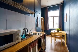 a small kitchen with a sink and a microwave at The Canal View Suites in Bruges