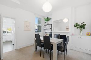 a dining room with a table and black chairs at Comfy 3 bed Home in London in Elmers End +13 photos