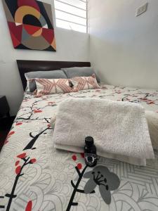 ボゴタにあるHabitaciones junto a Universidad del Bosqueのベッドルーム1室(時計付) +1枚の写真