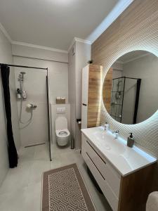 Un baño con inodoro, lavabo y espejo. en Stan na dan TowerLife Gradačac, en Gradačac