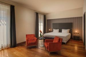 une chambre d'hôtel avec un lit et deux chaises dans l'établissement NH Collection Torino Santo Stefano, à Turin 45 autres photos