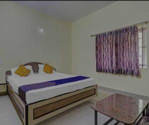 une chambre avec un lit, une fenêtre et une table dans l'établissement Golden cottage, à Yercaud