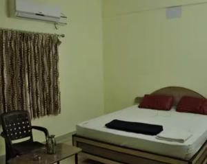 une chambre avec un lit, un bureau et une chaise dans l'établissement Golden cottage, à Yercaud